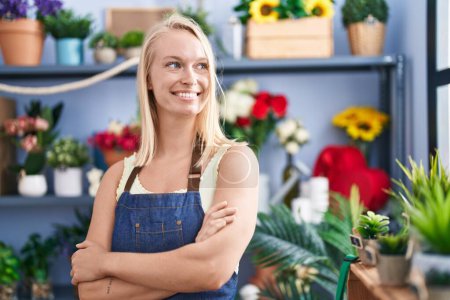 Photo for Young blonde woman florist smiling confident standing with arms crossed gesture at florist store - Royalty Free Image