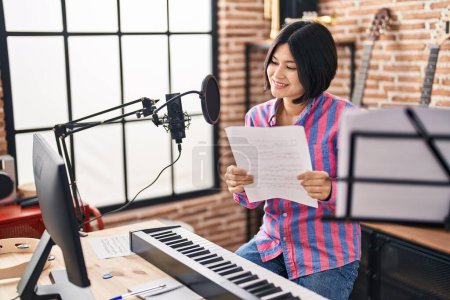 Photo for Young chinese woman artist singing song at music studio - Royalty Free Image