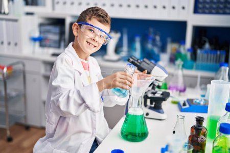 Photo for Blond child wearing scientist uniform measuring liquid at laboratory - Royalty Free Image