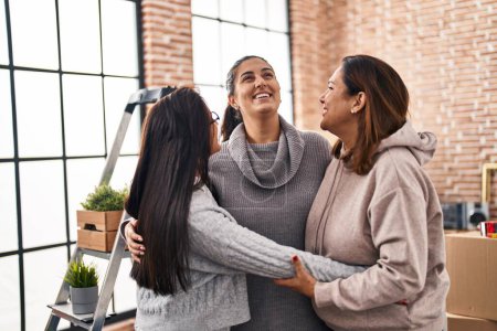 Téléchargez les photos : Three woman smiling confident hugging each other at new home - en image libre de droit
