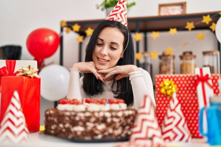 Téléchargez les photos : Jeune femme caucasienne célébrant anniversaire assis sur la table à la maison - en image libre de droit