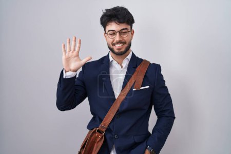 Téléchargez les photos : Homme hispanique avec barbe portant des vêtements de travail montrant et pointant vers le haut avec les doigts numéro cinq tout en souriant confiant et heureux. - en image libre de droit