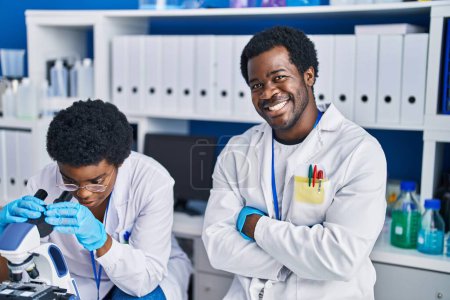 Foto de Científicos afroamericanos usando microscopio en laboratorio - Imagen libre de derechos