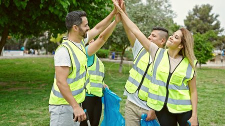 Foto de Grupo de voluntarios de cinco con las manos en el parque - Imagen libre de derechos