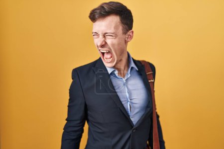 Photo for Caucasian business man over yellow background angry and mad screaming frustrated and furious, shouting with anger. rage and aggressive concept. - Royalty Free Image