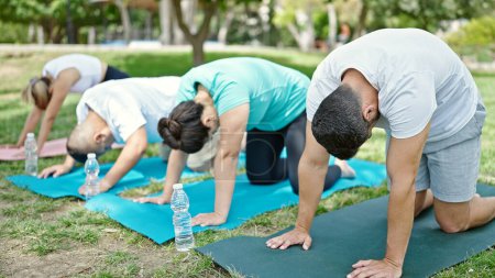 Photo for Group of people training yoga sitting on mat at park - Royalty Free Image