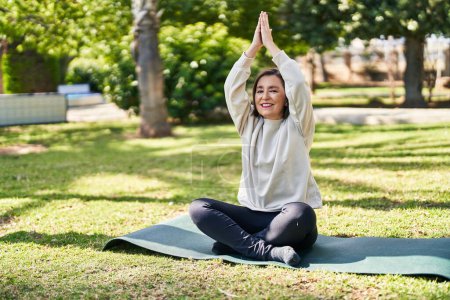 Photo for Middle age woman smiling confident training yoga at park - Royalty Free Image