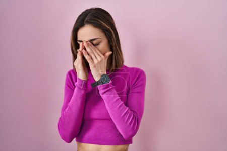 Photo for Hispanic woman standing over pink background rubbing eyes for fatigue and headache, sleepy and tired expression. vision problem - Royalty Free Image