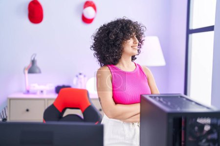 Téléchargez les photos : Young middle eastern woman streamer smiling confident standing with arms crossed gesture at gaming room - en image libre de droit