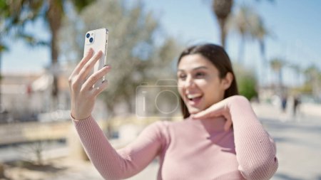 Téléchargez les photos : Jeune belle femme hispanique souriant confiant faire selfie par le smartphone au parc - en image libre de droit