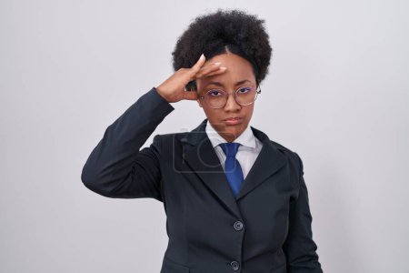 Foto de Hermosa mujer africana con el pelo rizado usando chaqueta de negocios y gafas preocupados y estresados por un problema con la mano en la frente, nervioso y ansioso por la crisis - Imagen libre de derechos