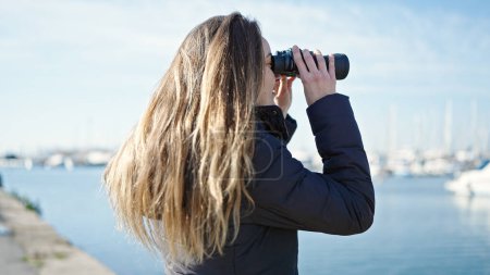 Foto de Mujer joven caucásica usando prismáticos en la playa - Imagen libre de derechos