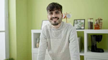 Téléchargez les photos : Jeune homme hispanique souriant confiant à la salle à manger - en image libre de droit