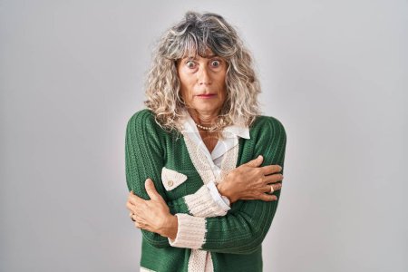 Photo for Middle age woman standing over white background shaking and freezing for winter cold with sad and shock expression on face - Royalty Free Image