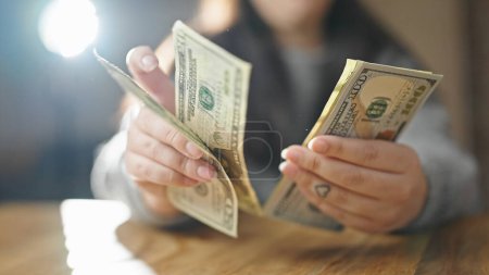 Foto de Manos de mujer contando dólares en la habitación - Imagen libre de derechos