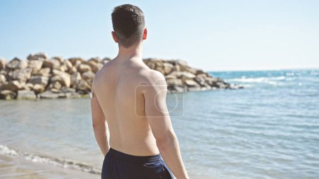 Foto de Joven turista hispano parado en la orilla del mar - Imagen libre de derechos