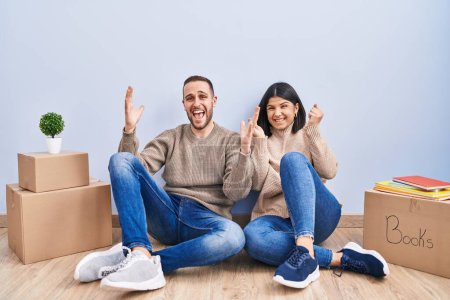Photo for Young couple moving to a new home celebrating mad and crazy for success with arms raised and closed eyes screaming excited. winner concept - Royalty Free Image