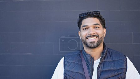 Téléchargez les photos : Africain américain souriant confiant debout sur fond noir isolé - en image libre de droit