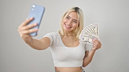 Foto de Joven hermosa mujer hispana sosteniendo dólares hacen selfie por teléfono inteligente sobre fondo blanco aislado - Imagen libre de derechos