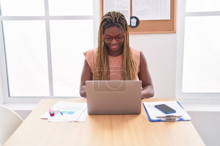 Foto de Trabajadora de negocios afroamericana usando laptop trabajando en oficina - Imagen libre de derechos