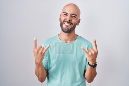 Photo for Middle age bald man standing over white background shouting with crazy expression doing rock symbol with hands up. music star. heavy music concept. - Royalty Free Image