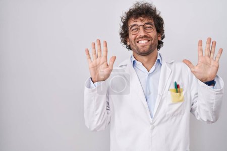 Photo for Hispanic young man wearing doctor uniform showing and pointing up with fingers number ten while smiling confident and happy. - Royalty Free Image
