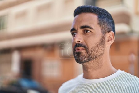 Téléchargez les photos : Young hispanic man with relaxed expression standing at street - en image libre de droit
