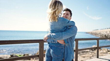Téléchargez les photos : Homme et femme couple souriant confiant s'embrassant au bord de la mer - en image libre de droit