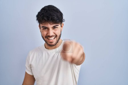 Foto de Hombre hispano con barba de pie sobre fondo blanco señalando disgustado y frustrado a la cámara, enojado y furioso con usted - Imagen libre de derechos