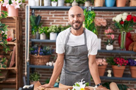 Photo for Young bald man florist smiling confident standing at florist - Royalty Free Image