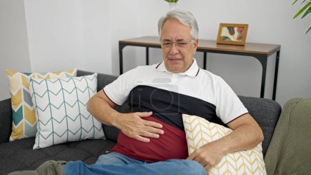 Photo for Middle age man with grey hair suffering for stomach ache at home - Royalty Free Image