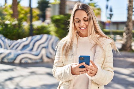 Photo for Young woman smiling confident using smartphone at park - Royalty Free Image