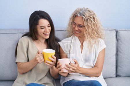 Foto de Two women mother and daughter drinking coffee at home - Imagen libre de derechos