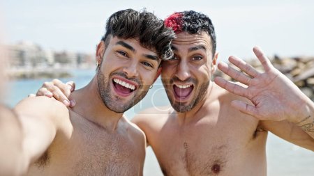 Two men tourist couple smiling confident having video call at beach
