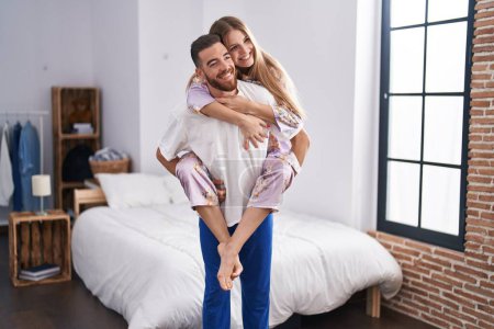 Téléchargez les photos : Homme et femme couple tenant petite amie sur le dos à la chambre - en image libre de droit
