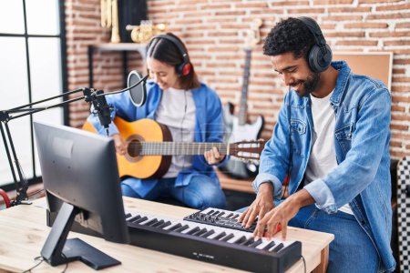 Photo for Man and woman musicians playing classical guitar and piano keyboard at music studio - Royalty Free Image