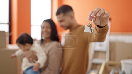 Téléchargez les photos : Couple et fils serrant les uns les autres tenant les clés à la nouvelle maison - en image libre de droit
