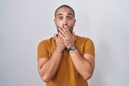 Photo for Hispanic man with beard standing over white background shocked covering mouth with hands for mistake. secret concept. - Royalty Free Image
