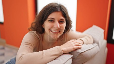 Téléchargez les photos : Jeune belle femme hispanique souriant confiant assis sur le canapé à la maison - en image libre de droit