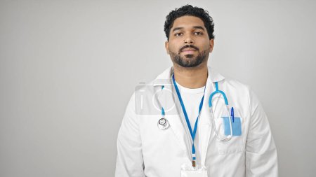 Foto de Médico hombre afroamericano de pie con expresión seria sobre fondo blanco aislado - Imagen libre de derechos