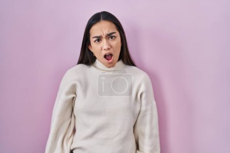 Téléchargez les photos : Jeune femme sud-asiatique debout sur fond rose dans le visage de choc, l'air sceptique et sarcastique, surpris avec la bouche ouverte - en image libre de droit