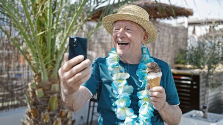 Photo for Senior grey-haired man tourist holding ice cream having video call at street - Royalty Free Image