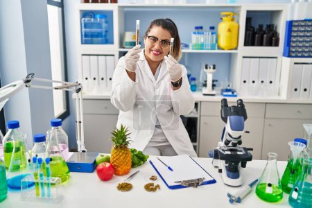 Photo for Young beautiful plus size woman scientist holding test tubes at pharmacy - Royalty Free Image