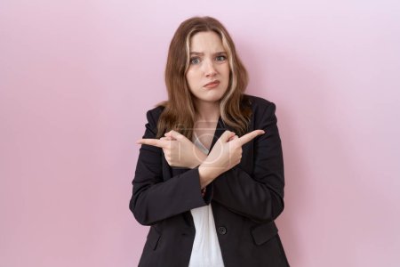Téléchargez les photos : Jeune femme d'affaires caucasienne portant une veste noire pointant des deux côtés avec les doigts, direction différente en désaccord - en image libre de droit