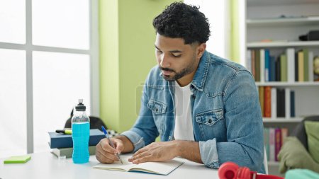 Photo for African american man student writing notes at library university - Royalty Free Image