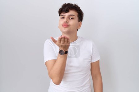 Photo for Young non binary man wearing casual white t shirt looking at the camera blowing a kiss with hand on air being lovely and sexy. love expression. - Royalty Free Image