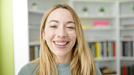 Photo for Young blonde woman student smiling confident standing at library university - Royalty Free Image