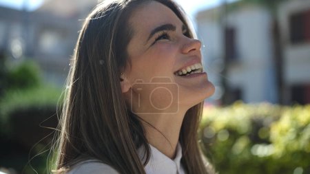 Foto de Joven hermosa mujer hispana sonriendo mirando a la calle - Imagen libre de derechos