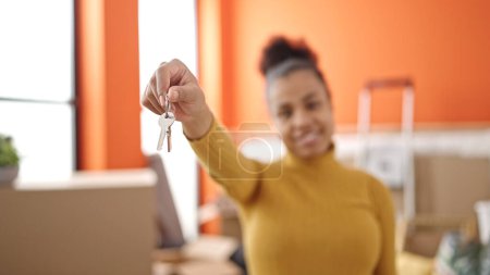 Photo for Young african american woman smiling confident holding key at new home - Royalty Free Image