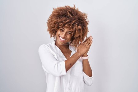 Photo for Young hispanic woman with curly hair standing over white background clapping and applauding happy and joyful, smiling proud hands together - Royalty Free Image
